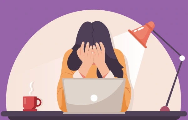 Alt Text: Overwhelmed international student sitting at laptop stressed by first week paperwork and bureaucracy in Prague
